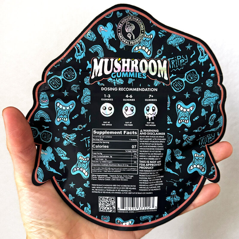 Hand holding a black and blue Tre house 'Mushroom Gummies' packaging